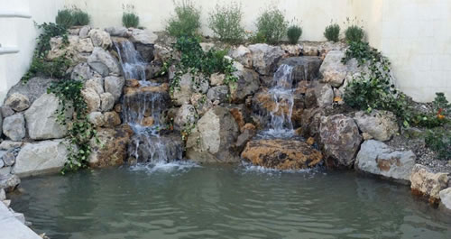 The finished installation includes two cascading waterfalls between a natural setting of rocks accented with live plants.